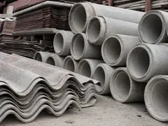 Stacked asbestos cement pipe and corrugated cement roofing sheets