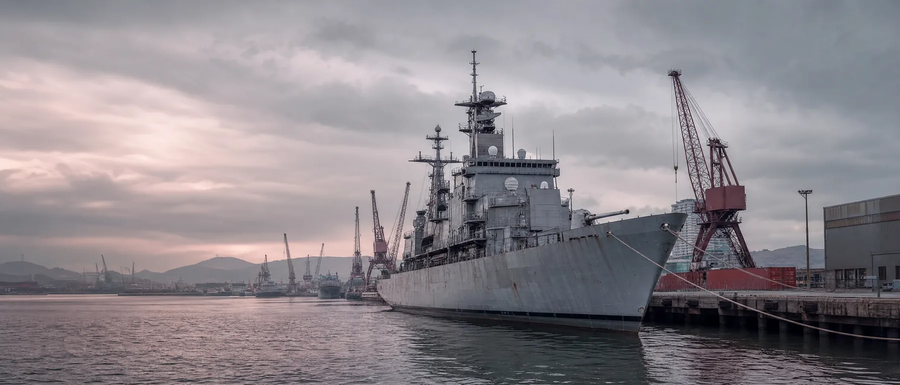 Old navy ship at a shipyard pier, where many veterans met asbestos