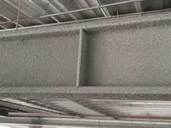 Spray-on asbestos fireproofing on steel beams with loose vermiculite